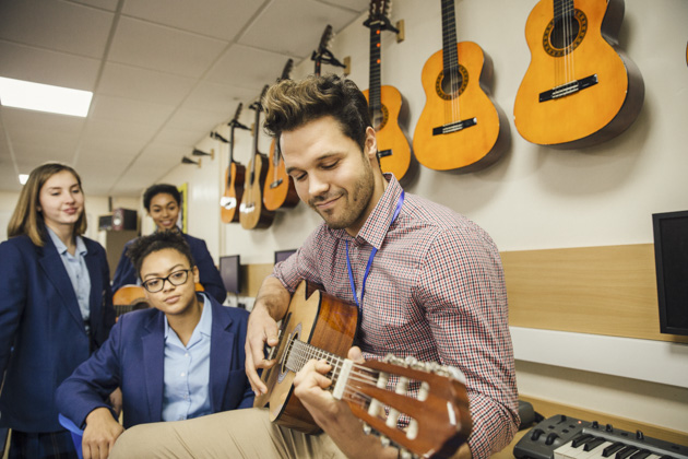 Music Instructors, music instructor teaching the guitar to multiple students 