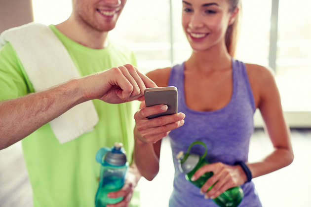 new year's fitness resolutions, Happy client and personal trainer looking at phone
