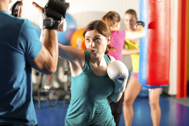 martial arts marketing, Female kick boxer sparring with trainer