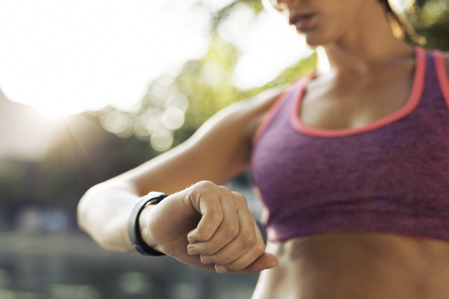 fitness industry technology trends, Runner checking her fitness smart watch device